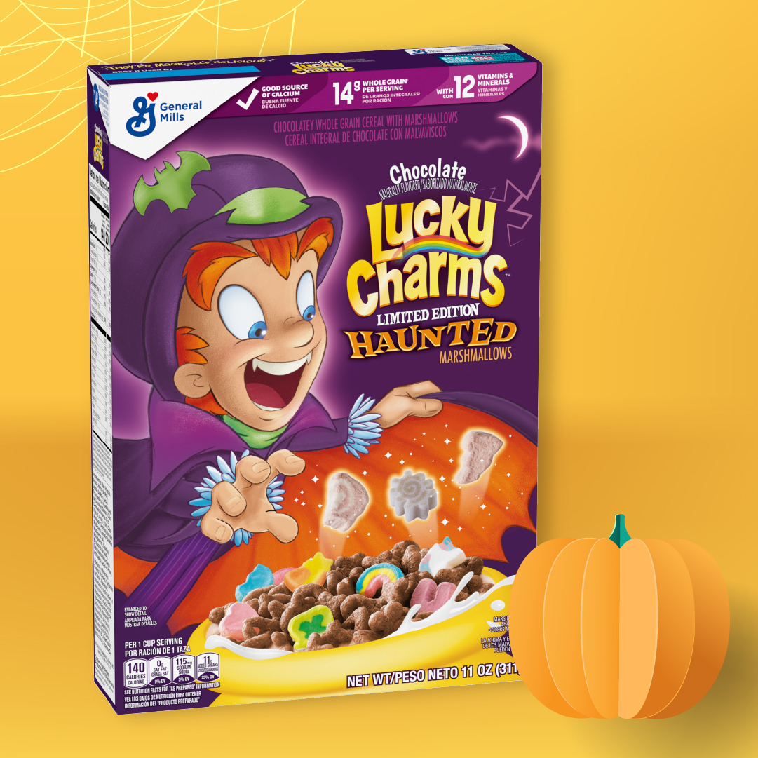 Lucky Charms Haunted Marshmallows cereal box displayed on a yellow background with a pumpkin illustration.