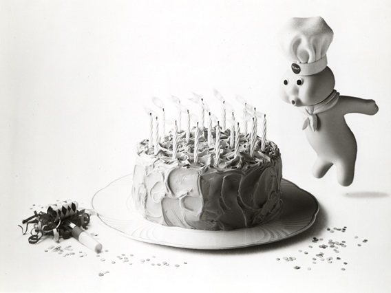 Pillsbury doughboy blowing out candles on a birthday cake